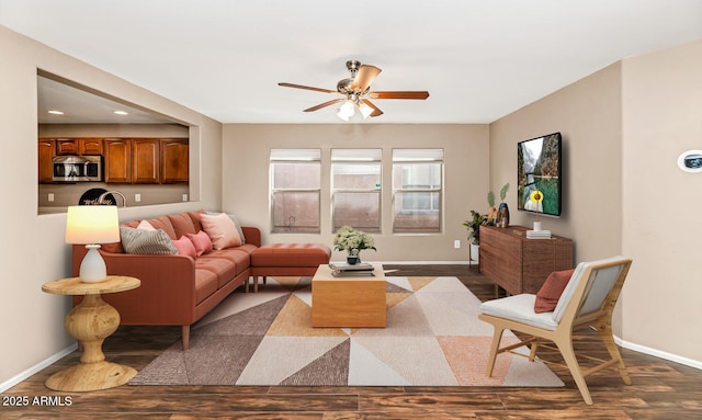 living room featuring dark wood-style floors, a ceiling fan, and baseboards