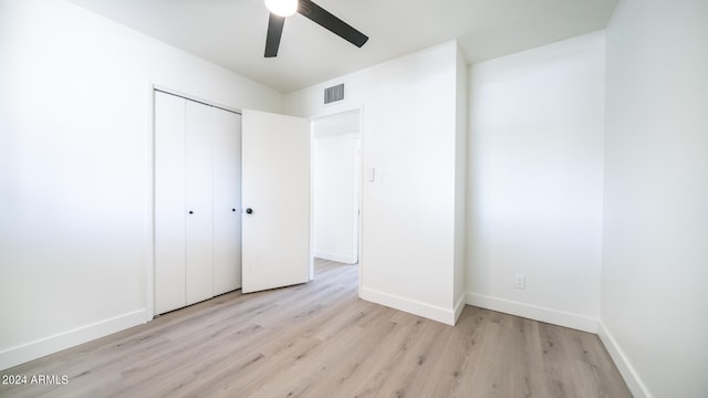 unfurnished bedroom with a closet, light hardwood / wood-style floors, and ceiling fan