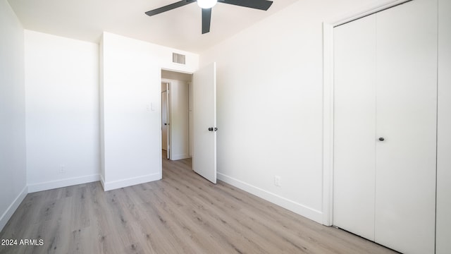 unfurnished bedroom with light hardwood / wood-style flooring, a closet, and ceiling fan