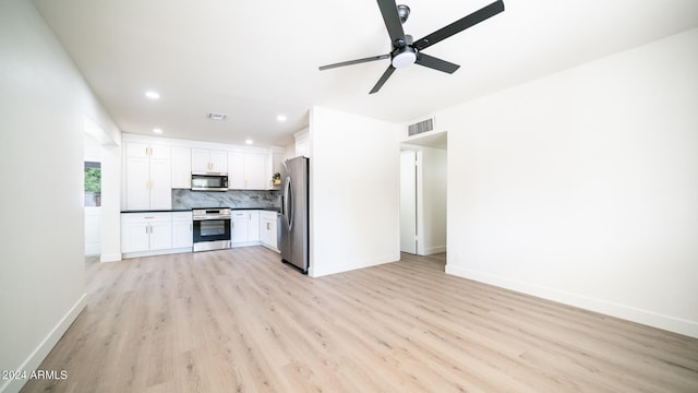 kitchen featuring white cabinets, tasteful backsplash, ceiling fan, light wood-type flooring, and stainless steel appliances