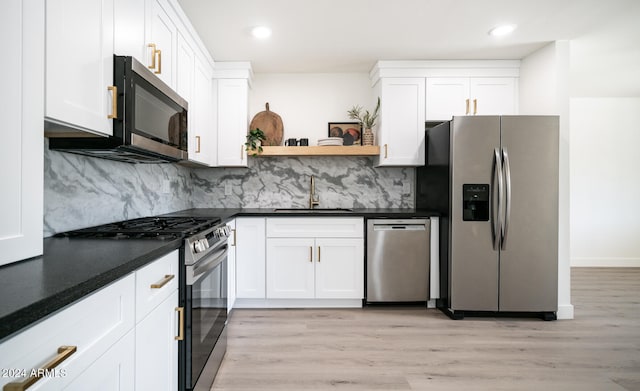 kitchen featuring sink, white cabinetry, stainless steel appliances, and light hardwood / wood-style floors