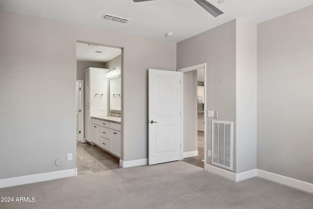 unfurnished bedroom featuring connected bathroom, ceiling fan, and light carpet