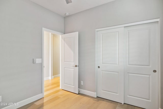 unfurnished bedroom featuring a closet, hardwood / wood-style flooring, and ceiling fan