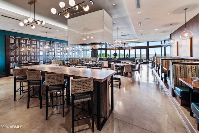 bar featuring pendant lighting, a chandelier, and a wall of windows