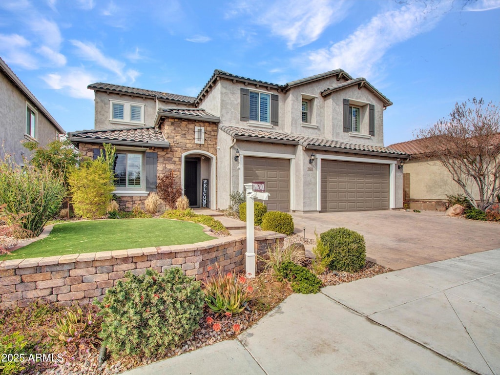 mediterranean / spanish-style house featuring a garage and a front lawn