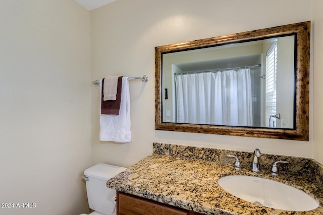 bathroom with a shower with shower curtain, vanity, and toilet