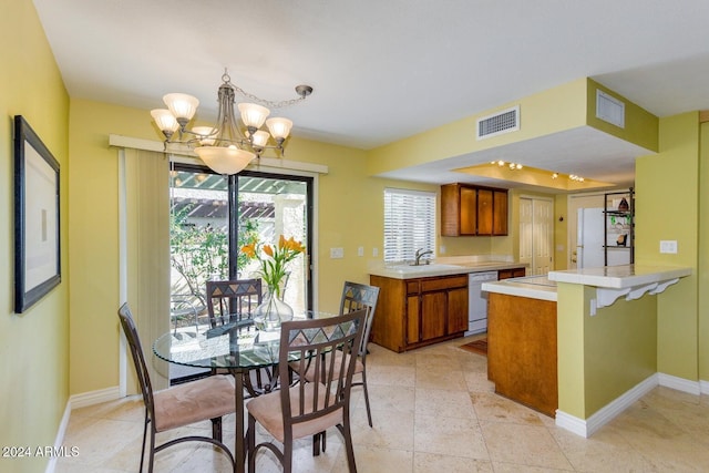 dining room featuring a chandelier, rail lighting, and sink