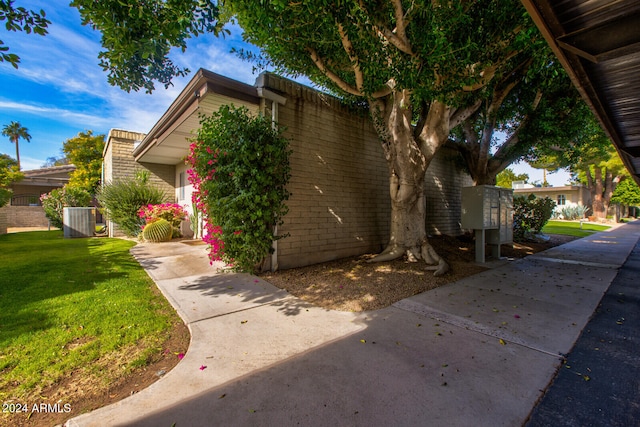 view of front of home with cooling unit and a front lawn