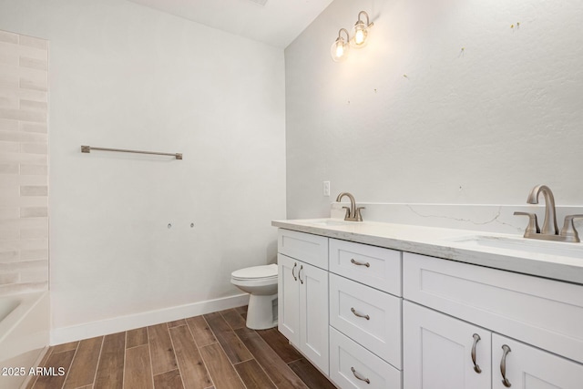 bathroom featuring toilet, vanity, and a tub to relax in