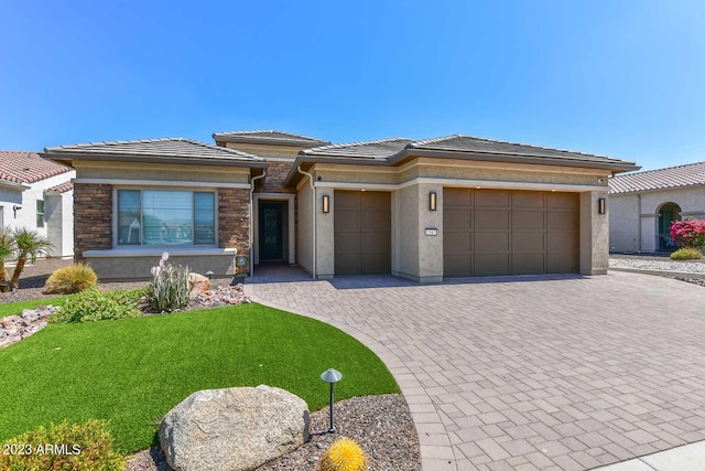 prairie-style house with a garage and a front lawn