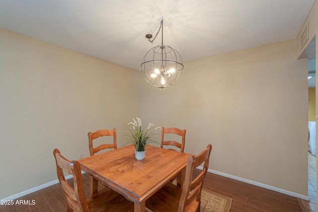 dining room featuring dark hardwood / wood-style floors and an inviting chandelier