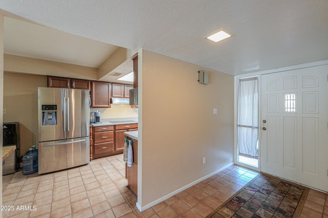 entryway featuring light tile patterned flooring and a textured ceiling