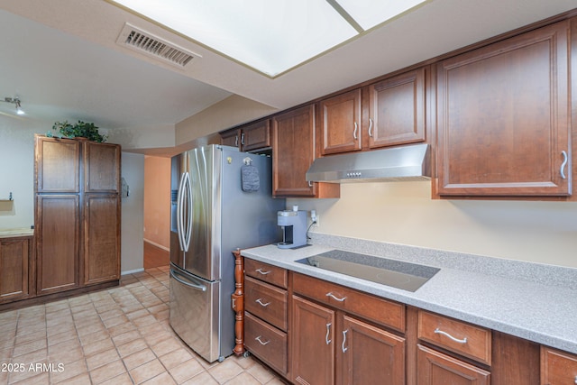 kitchen featuring black electric cooktop and stainless steel refrigerator with ice dispenser