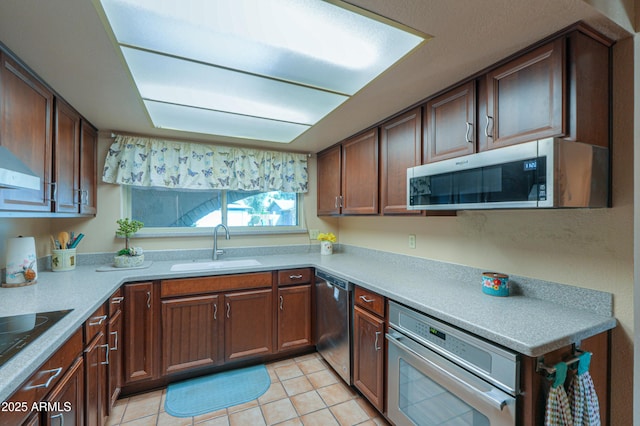 kitchen with sink, stainless steel appliances, and light tile patterned flooring