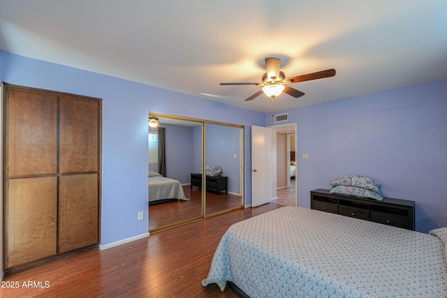 bedroom with multiple closets, ceiling fan, and wood-type flooring