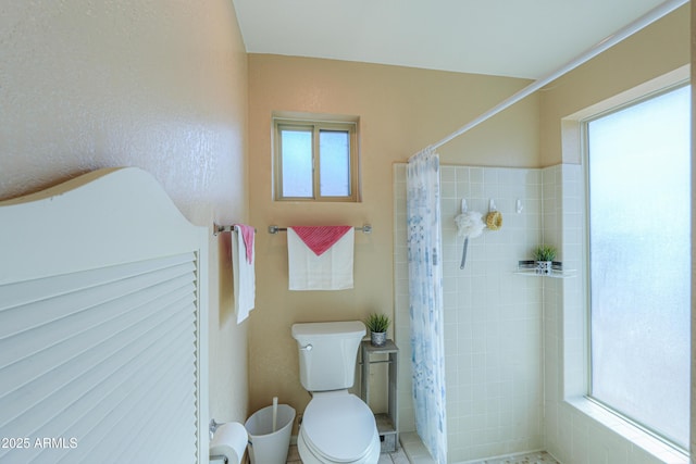 bathroom with toilet and a shower with shower curtain