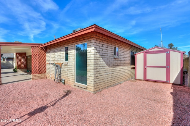 view of side of home featuring a patio and a shed