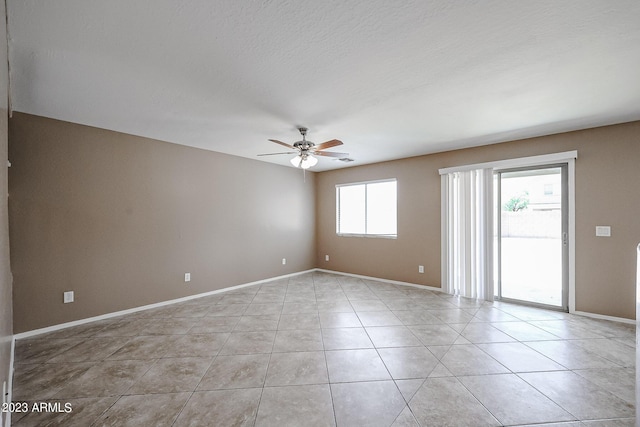 tiled empty room featuring ceiling fan