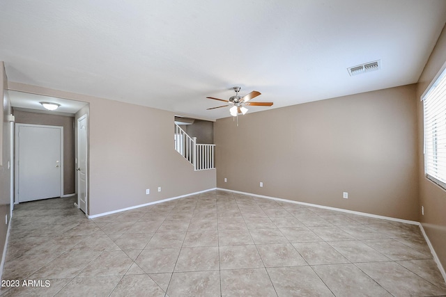 tiled empty room featuring ceiling fan