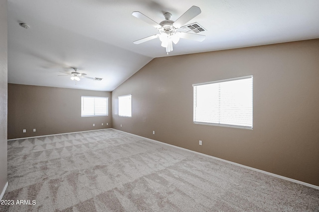 spare room featuring ceiling fan, light colored carpet, and lofted ceiling