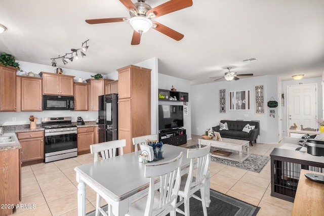 kitchen featuring visible vents, open floor plan, light tile patterned floors, black appliances, and a ceiling fan