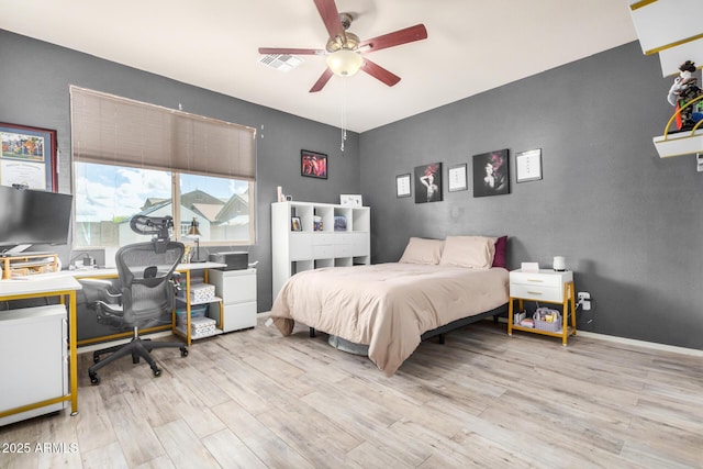 bedroom with visible vents, a ceiling fan, baseboards, and wood finished floors