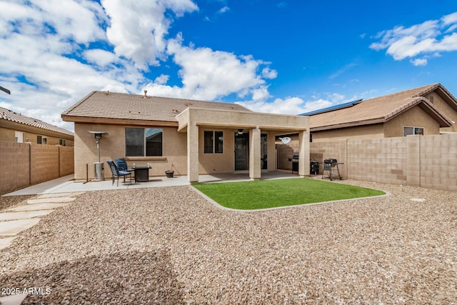 rear view of property with a fenced backyard, ceiling fan, stucco siding, a tiled roof, and a patio area