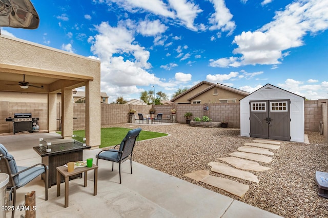 view of patio featuring an outbuilding, a fenced backyard, a shed, grilling area, and ceiling fan