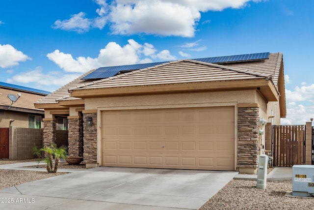 view of front of property featuring stone siding, roof mounted solar panels, driveway, and a tile roof