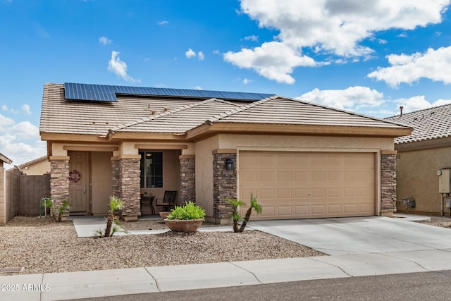 prairie-style home with solar panels, stone siding, and driveway