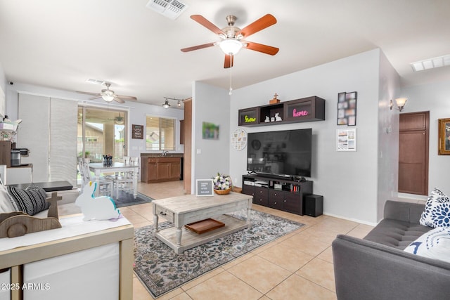 living room with light tile patterned floors, visible vents, and a ceiling fan