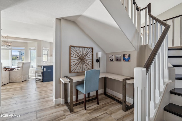 office with wood tiled floor, vaulted ceiling, baseboards, and an inviting chandelier