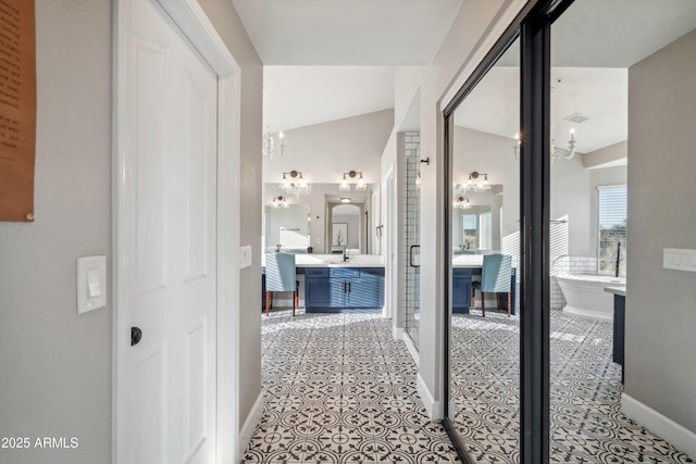 hallway with a chandelier, light tile patterned flooring, visible vents, and baseboards