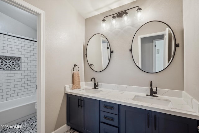 bathroom with a sink, shower / bathing tub combination, and double vanity