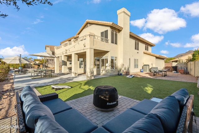 back of house featuring stucco siding, a patio, fence, and an outdoor hangout area