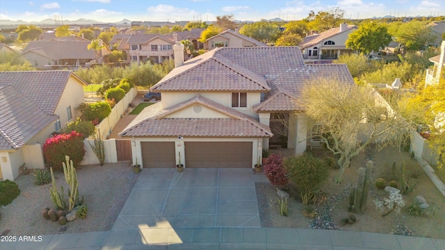 view of front of home featuring a garage, a tiled roof, concrete driveway, a residential view, and stucco siding