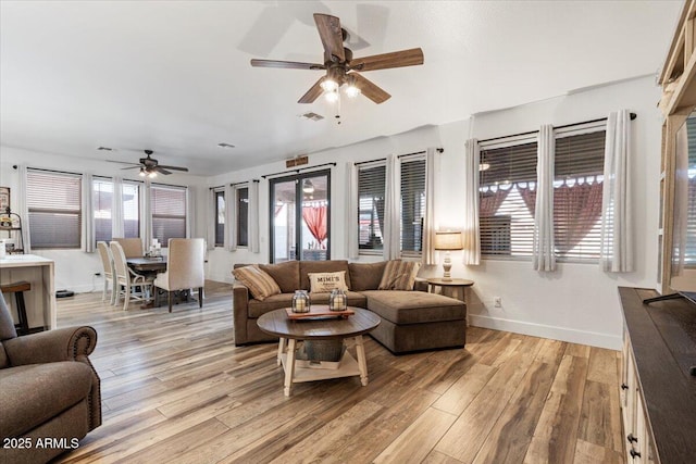 living room featuring ceiling fan and light hardwood / wood-style flooring