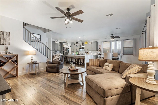 living room with light hardwood / wood-style floors and ceiling fan