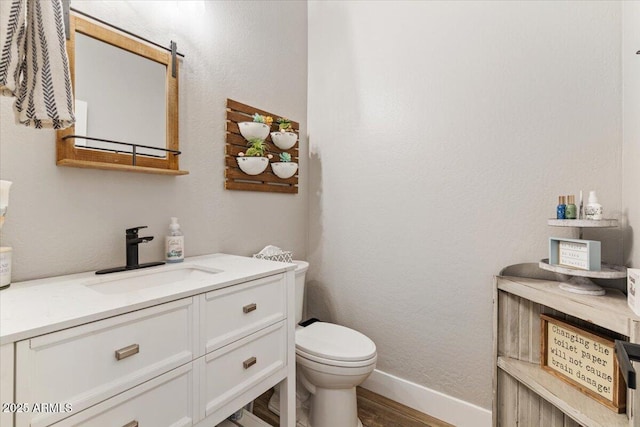 bathroom with vanity, wood-type flooring, and toilet