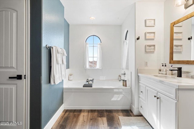 bathroom featuring vanity, hardwood / wood-style floors, and a washtub