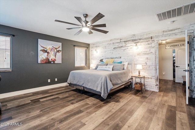 bedroom featuring multiple windows, hardwood / wood-style flooring, and ceiling fan