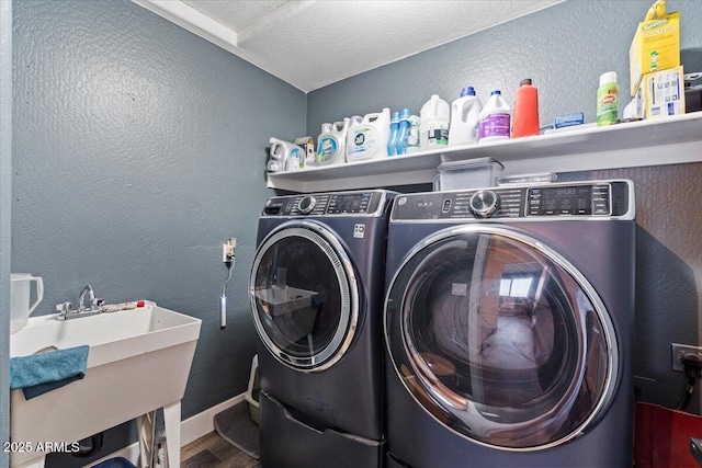 washroom featuring wood-type flooring, sink, and washing machine and dryer