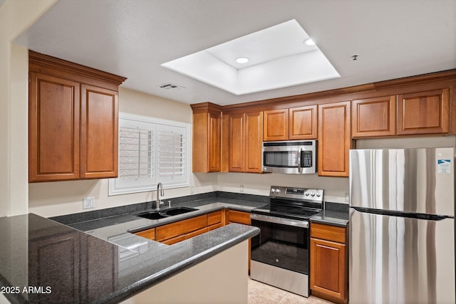 11375 E Sahuaro Dr Unit 2033, Scottsdale, AZ 85259 - kitchen featuring appliances with stainless steel finishes, brown cabinets, a peninsula, dark stone countertops, and recessed lighting
