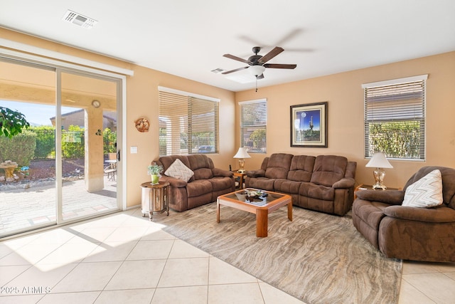 living room featuring ceiling fan, tile patterned flooring, visible vents, and a healthy amount of sunlight