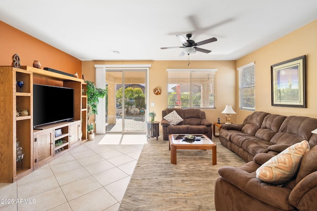 living room featuring light tile patterned floors, visible vents, and a ceiling fan