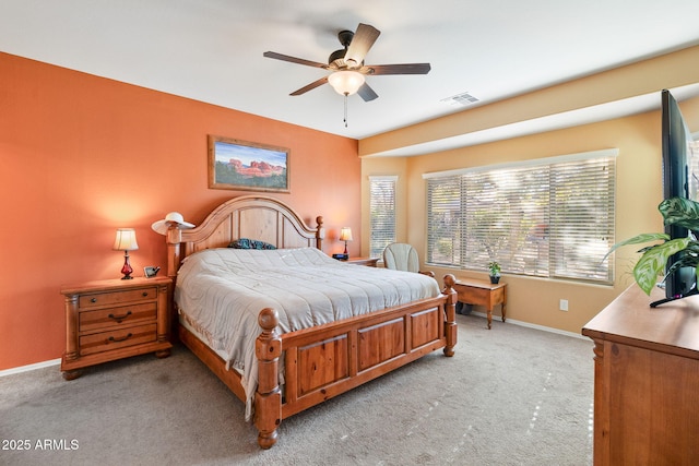 bedroom featuring light carpet, visible vents, baseboards, and ceiling fan