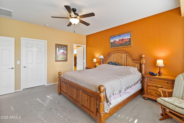 carpeted bedroom featuring ceiling fan, visible vents, and baseboards