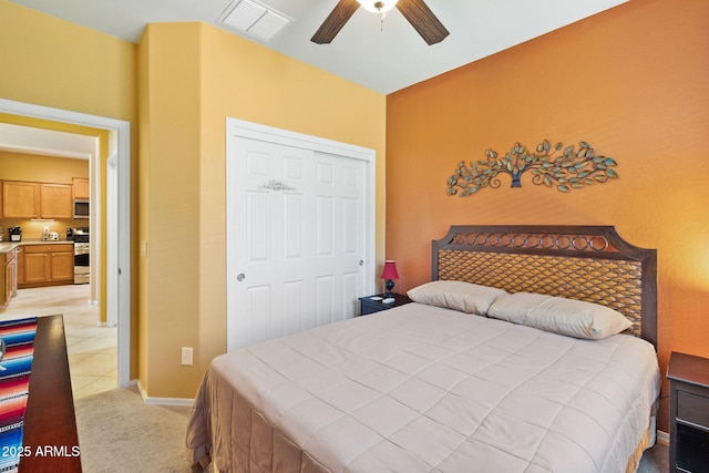 bedroom featuring a closet, visible vents, a ceiling fan, light carpet, and baseboards