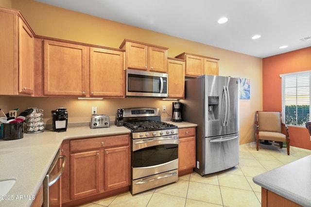 kitchen featuring light tile patterned floors, brown cabinetry, stainless steel appliances, light countertops, and recessed lighting