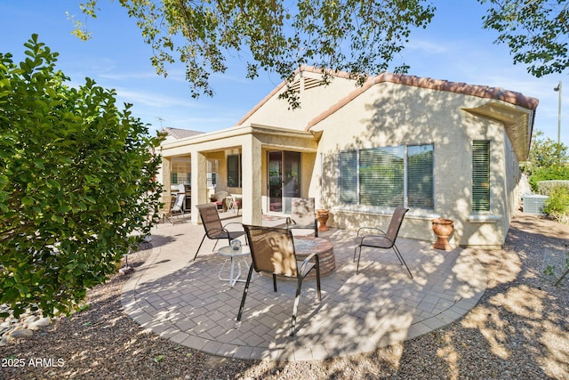 rear view of property featuring stucco siding and a patio